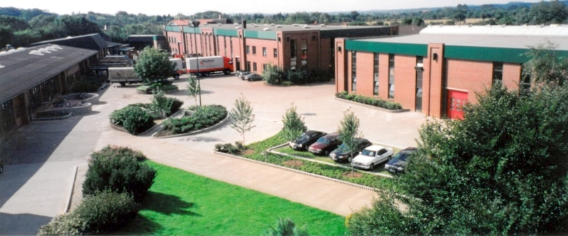 1999: Erweiterung, 7000 qm Produktionsfläche Luftaufnahme vom Innenhof mit Lagerhallen und Parkplatz